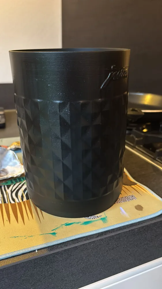 Zwarte opvangbak met diamantpatroon voor een koffiemachine