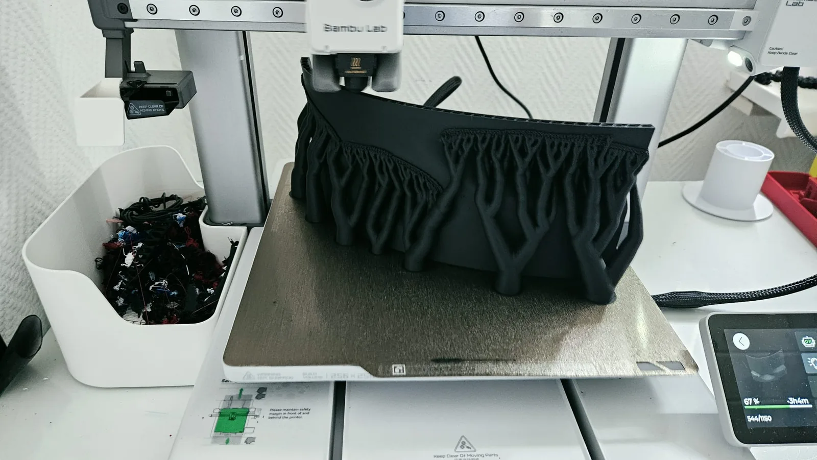 Bambu Lab-printer die een zwart onderdeel laag voor laag opbouwt